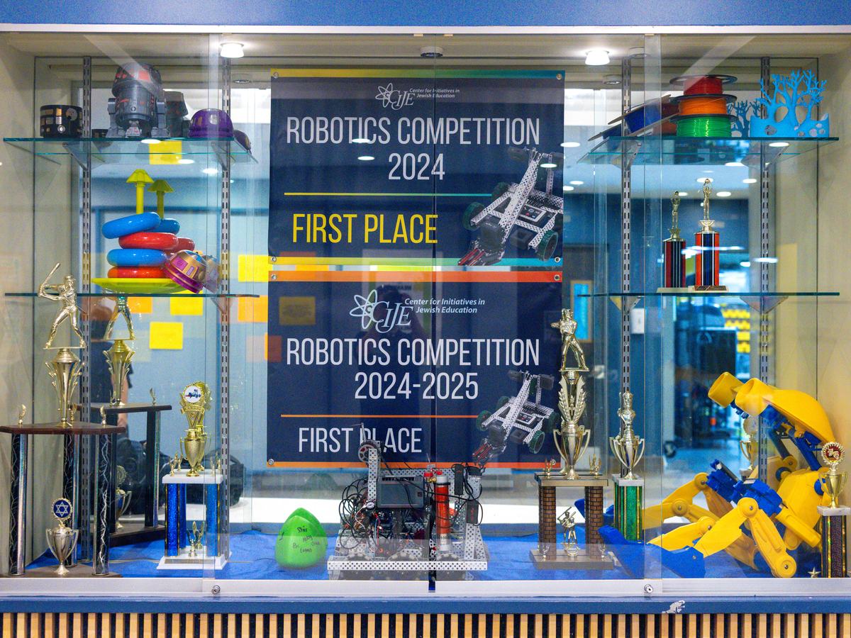 The WHHS robotics trophy case, with VEX championship banners, competition robots and trophies